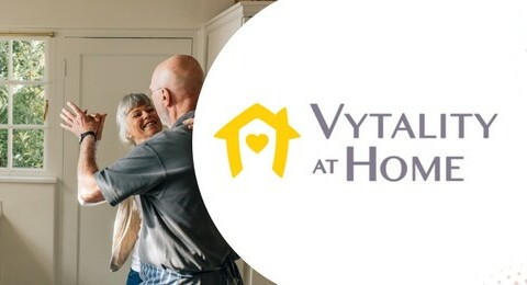 A senior couple dancing in their kitchen with the Vytality at Home logo