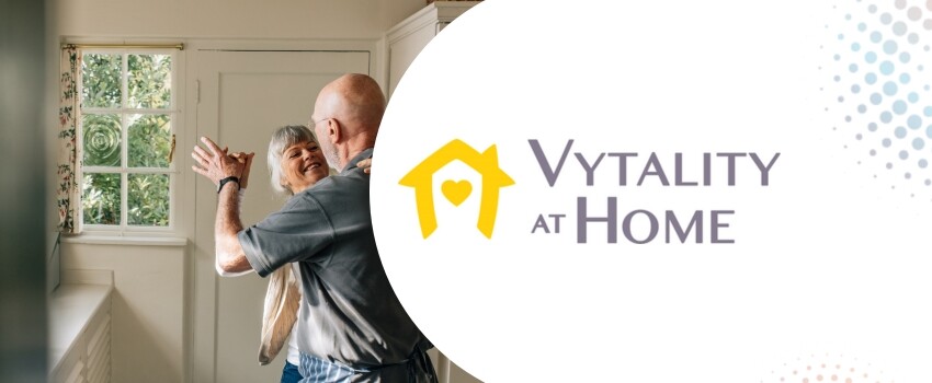 A senior couple dancing in their kitchen with the Vytality at Home logo